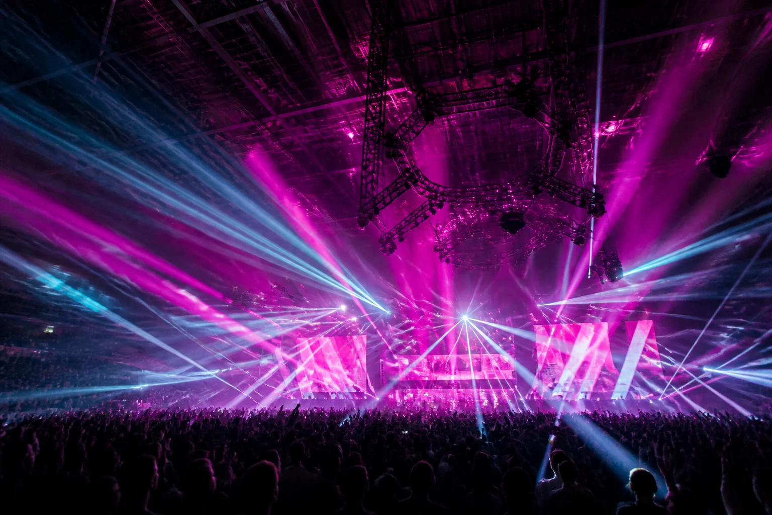 Concert light beams and stadium crowd